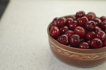 Red cherry in a bowl. Red sweet cherry background.