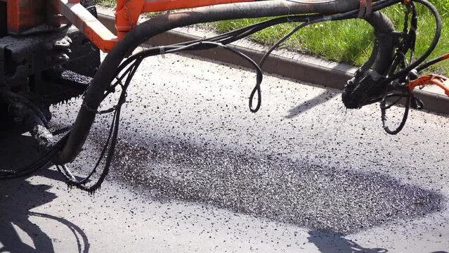 Road worker sprays hot bitumen to cover holes or cracks in the asphalt road.