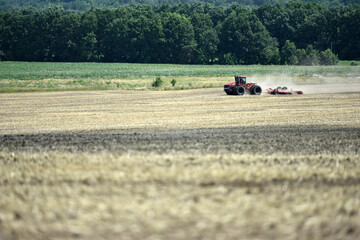 Kyiv, Ukraine, 19.07.2023. Red tractor with a plow on an agricultural field. work in the field. farmland, tractor in the field. mechanism, Tractor plowing land. Harvester sowing wheat. Editorial