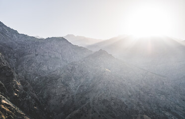 Rocky mountain range in Tajikistan in the haze early sunny morning in the sun's rays, landscape of mountains for the background texture