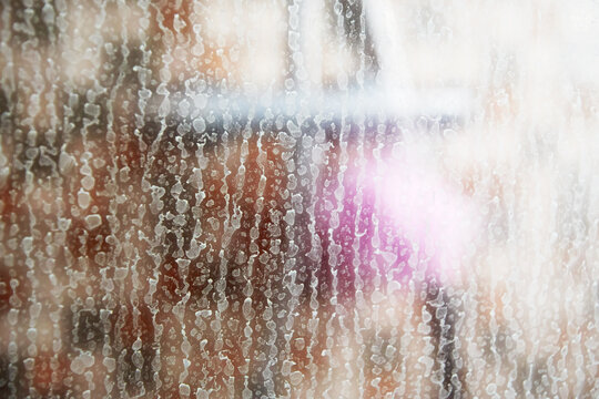 Blurred shower cabin and faucet and detailed view of limescale on the glass. Housekeeping and cleaning concept