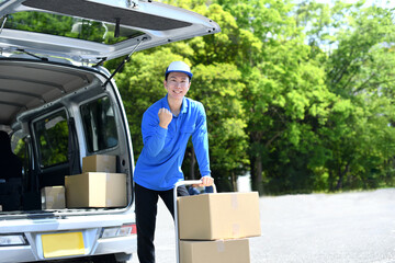 台車で荷物を運ぶ男性の配送ドライバー