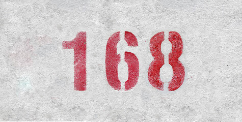 Red Number 168 on the white wall. Spray paint.