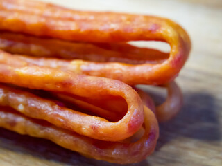 The sausages’ presentation on wood conveys a warm, inviting mealtime atmosphere. The image could be part of a series showcasing different cooking methods for meats.