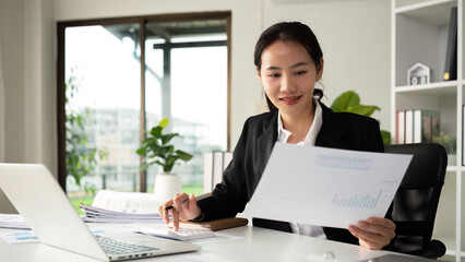 Business woman using calculator for do math finance on wooden desk in office and business working background, tax, accounting, statistics and analytic research concept