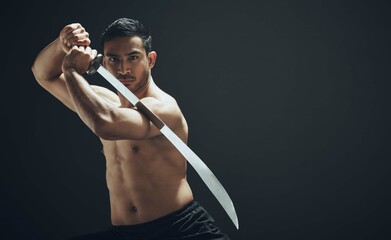 Man, samurai sword and portrait in studio for training, exercise and martial arts for mockup. Blade, wellness and ninja or warrior by black background for karate, fight and aikido for dojo in Japan © Lumeez23/peopleimages.com