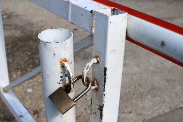 An old metal lock hangs on the fence.
