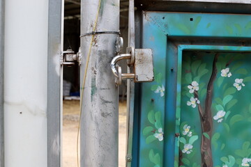 An old metal lock hangs on the fence.