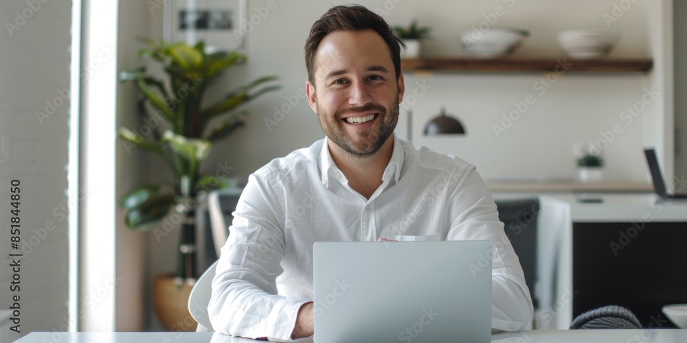 Poster an workplace with a smiling young caucasian businessman using a laptop. while perusing the web and e