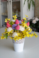 Bouquet of fake yellow flowers with colorful soy wax strawberry candles
