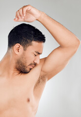 Grooming, man and armpit with bad smell in studio for routine, wellness and skincare for hygiene on white background. Male person, underarm and stink of sweat or body odor for fragrance or cologne