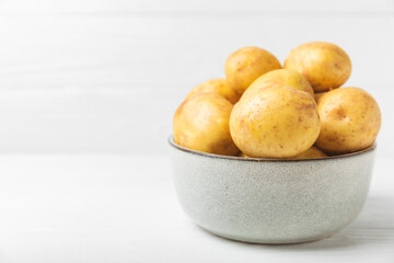 Young potatoes. Fresh potatoes  on a wooden background.Harvesting collection. organic, freshly dug potatoes. Agricultural background. Vegan. Vegetables.Place for text.Copy space