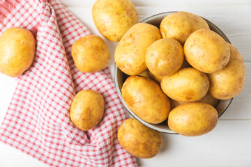 Young potatoes. Fresh potatoes  on a wooden background.Harvesting collection. organic, freshly dug potatoes. Agricultural background. Vegan. Vegetables.Place for text.Copy space