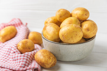 Young potatoes. Fresh potatoes  on a wooden background.Harvesting collection. organic, freshly dug potatoes. Agricultural background. Vegan. Vegetables.Place for text.Copy space
