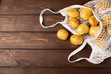 Young potatoes. Fresh potatoes  on a wooden background.Harvesting collection. organic, freshly dug potatoes. Agricultural background. Vegan. Vegetables.Place for text.Copy space