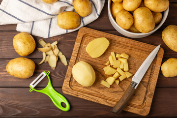 Young potatoes. Raw potatoes and knife on a wooden background.Peel potatoes.Harvesting collection. organic, freshly dug potatoes. Agricultural background. Vegan. Vegetables.Place for text.Copy space