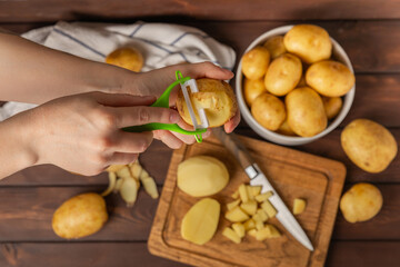 Young potatoes. Raw potatoes and knife on a wooden background.Peel potatoes.Harvesting collection. organic, freshly dug potatoes. Agricultural background. Vegan. Vegetables.Place for text.Copy space