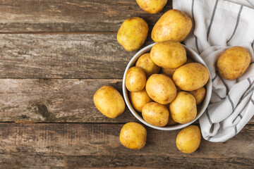 Young potatoes. Fresh potatoes  on a wooden background.Harvesting collection. organic, freshly dug potatoes. Agricultural background. Vegan. Vegetables.Place for text.Copy space