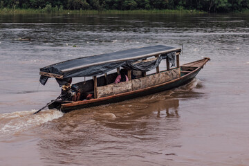 Bote de madera con motor, navegando el río Huallaga, desde el Puerto Garcilazo de la ciudad de...