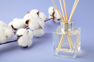 Cotton reed diffuser on purple background.