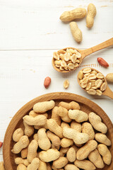 Fresh healthy peanuts in bowl and spoon on white background.