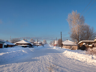 Snowy road in countryside with snow drifts in frosty winter.