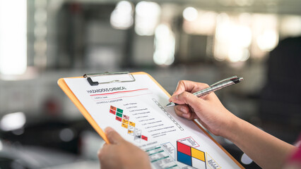 Action of a safety supervisor hand is checking on checklist of chemical and hazardous material form...