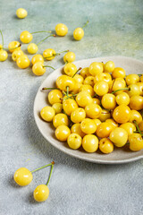 yellow cherry, cherry berry, scattered on a plate, top view, no people,
