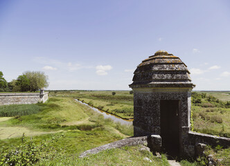 Bastions, tourelles et courtines sur les remparts de la Citadelle fortifiée de Hiers-Brouage face au vaste paysage du marais Charentais et des chenaux ensablés
