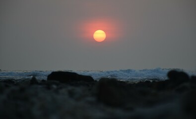sunset over the sea with white wave and wild rock .orange sun with sea scape  at  khaolak  thailand