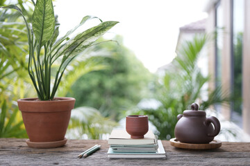 Tea cup and earthenware teapot at the balcony and Peace lily pot at balcony outdoor