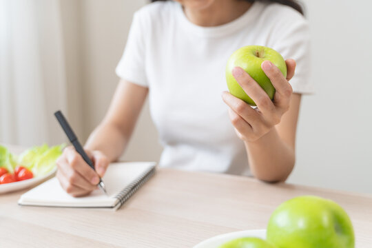 Wellbeing of health with good food control concept. Woman writing the meal note and plan to eat during diet program to loss weight goal for balance nutrition and calories.