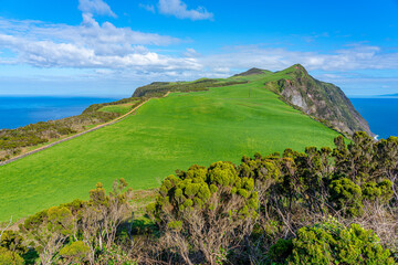 Plateau with lush green vegetation looking like a golf course observed from the whale lookout next to the Rosais lighthouse.