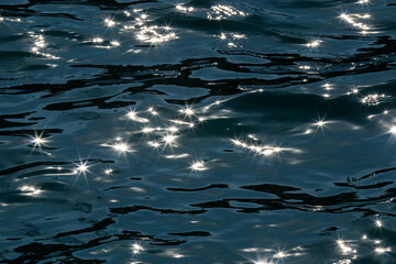 Sea background. Low key. Lens Flare. Play of light in photography. Picturesque sea surface .