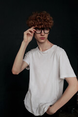 A young curly-haired man in stylish glasses. Red curls.