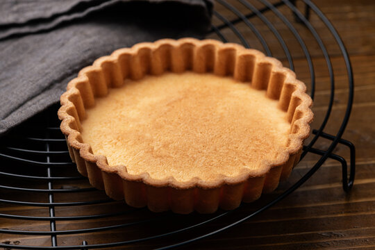 木のテーブルの上にケーキクーラにのせたクッキートルテ