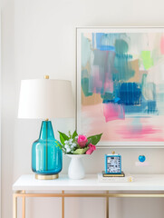 Pastel interior design with console gold metallic table, blue coastal lamp, vase and flowers. Bright colors and white walls. Home decor. Abstract art work on wall