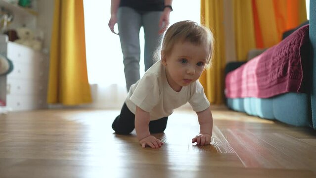 Happy toddler learning walk in kindergarten. Nanny helps toddler care support. toddler development in kindergarten. Concept care support. Teaching toddler step by step in kindergarten with help nanny.