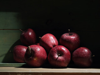 Red organic grown apples with in wooden box in bright sunlight with copyspace. Natural fruit from garden concept image.