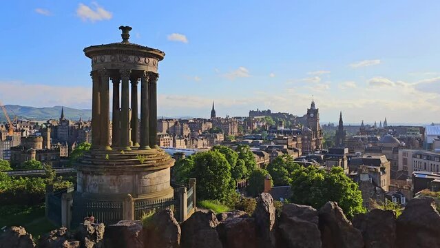Slow panning motion over the old city of Edinburgh, Scotland from Calton Hill near sunset