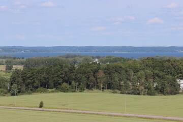 Obraz premium Sweden. Wheat grows on a field in the city of Linköping. In the background is Lake Roxen and the city Berg. Östergötland County.
