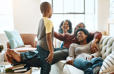 Fototapeta premium Relax, bonding and black family on sofa in home for hugging, love and care on fathers day for celebration. Smile, couch and African kids with mom and day resting together in living room at house.