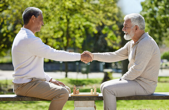 Mature men, handshake and success in chess for game, challenge or sport for healthy mind, practice and planning. Male people, outdoor and play for moves or gambit as champion in competition as master