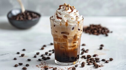 Iced coffee topped with whipped cream and coffee beans on a white surface