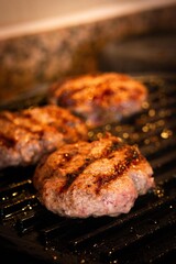 burger patties on iron grill and smoke