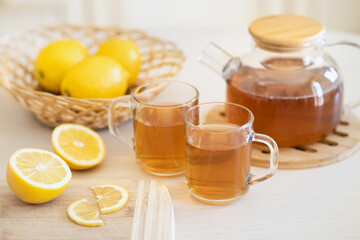 Tea with slice of lemon and honey on wooden table and blue background