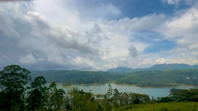 Panoramic view of a stunning highland landscape featuring mountain ranges, lush tea plantations, and a serene lake. Perfect for travel, nature, and scenic beauty themes.