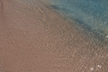 Sandy beach background. Gentle waves crash upon the shore. Pink sand. Pink shells. Elafonisi. Crete. Greece.