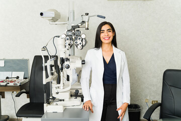Professional optometrist stands beside advanced eye examination equipment in a clinic, ready to assist patients with their vision needs © AntonioDiaz