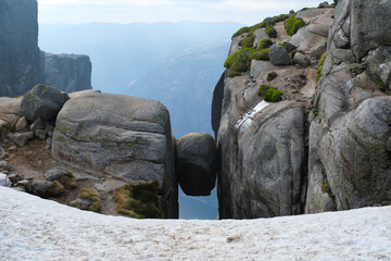 round large stone between the rocks with snow